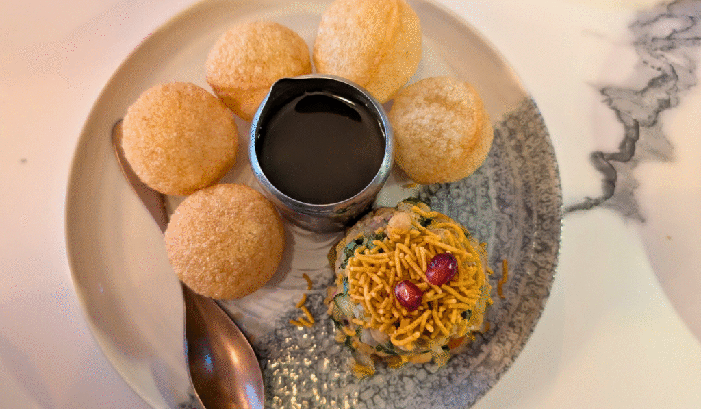 Image of Chaat Bombs on a plate with tamarind sauce and potato chaat 