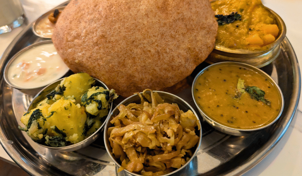 Veg Thali served on a tray with poori